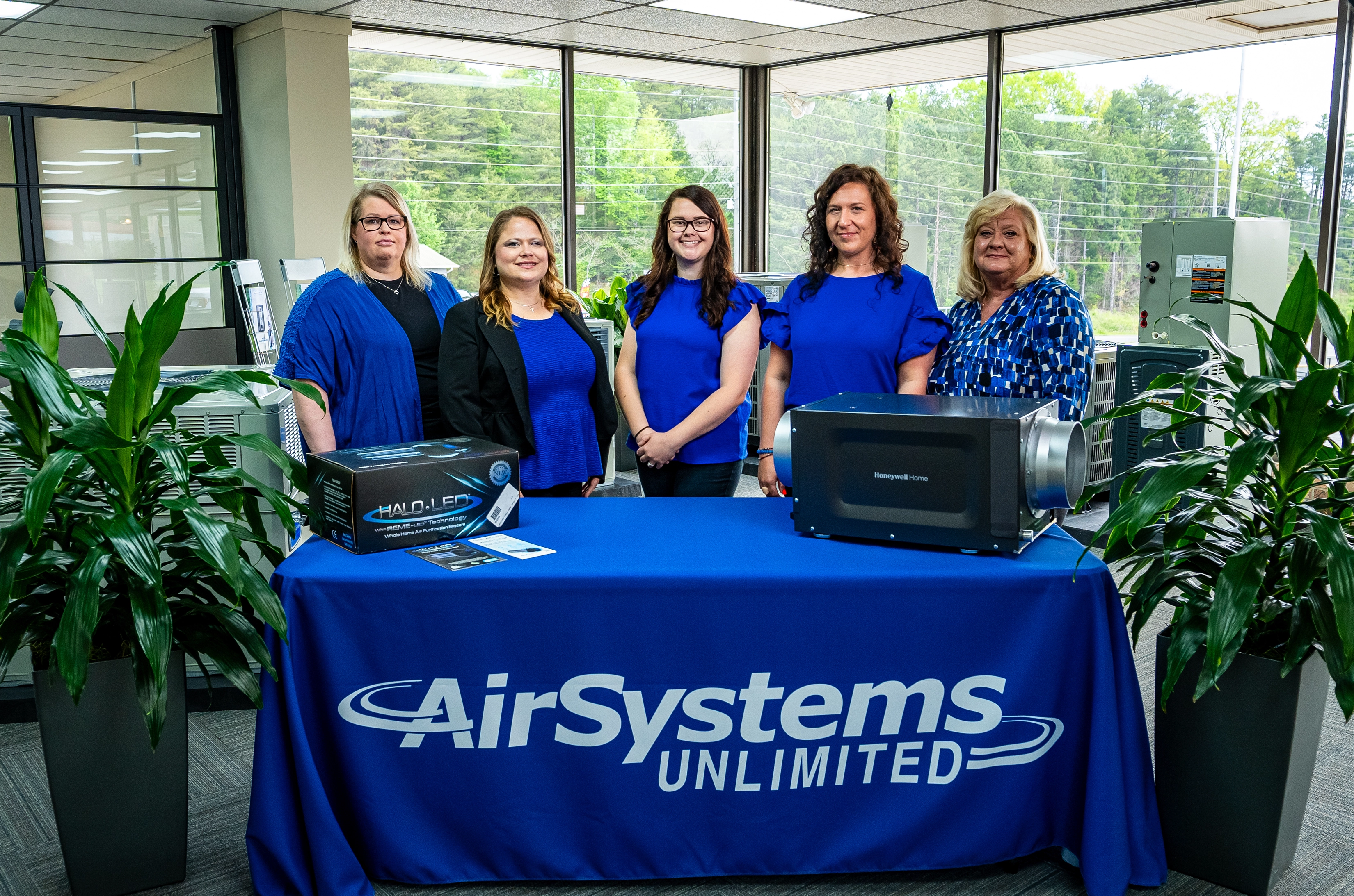 employees pose behind booth